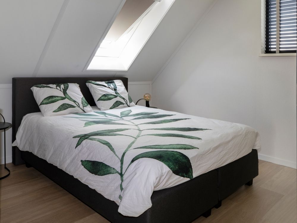 Slaapkamer onder schuin dak met dakraam