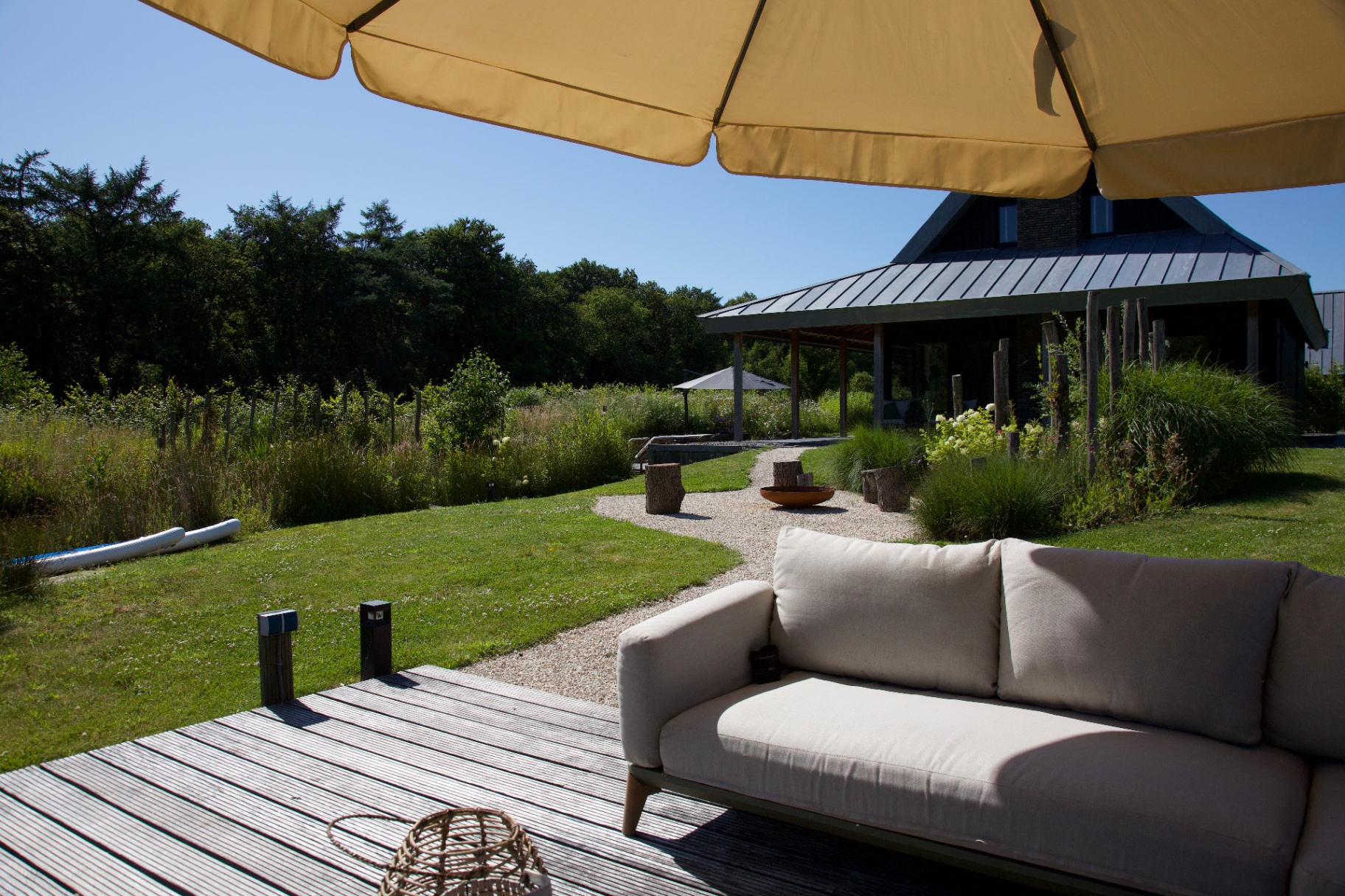 Tuin met buitensofa en gele parasol